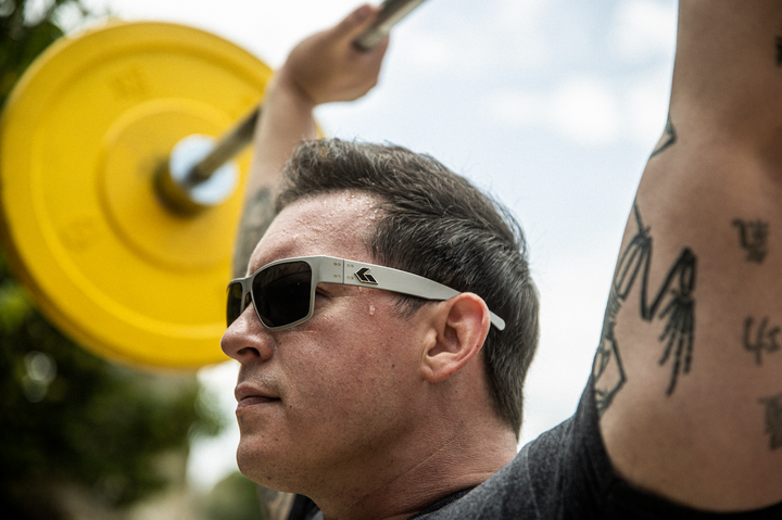 ADF male soldier lifting a barbell with weights outdoors wearing Gatorz Delta Sunglasses
